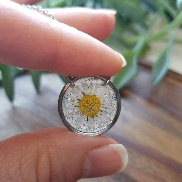 Add a little sparkle to your jewelry collection with this beautifully crafted pressed daisy flower pendant necklace.