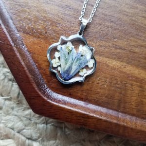 Add a touch of whimsy to your wardrobe with this one of a kind dried blue wildflower resin Necklace.