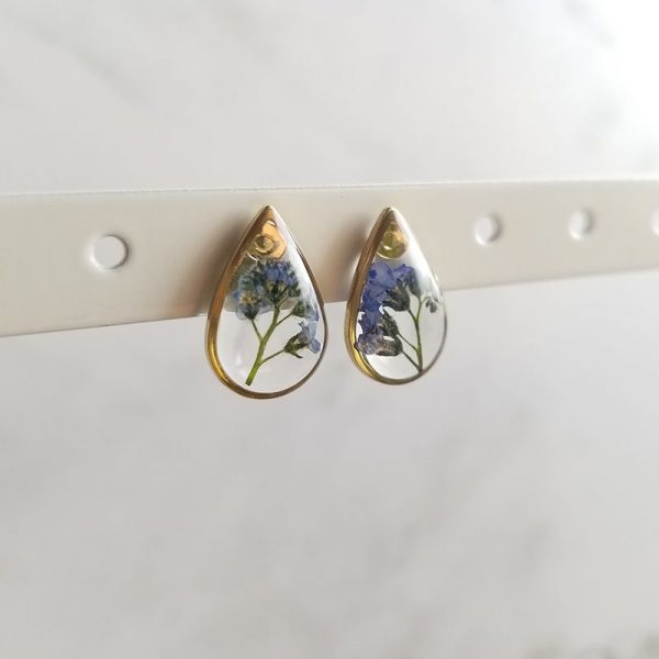 Add a touch of whimsy to your accessory collection with these dried forget me not flower resin stud earrings.