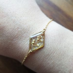 Add a touch of whimsy to your wardrobe with this one of a kind hand pressed flower bud resin bracelet.