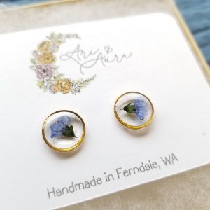 Add a touch of whimsy to your accessory collection with these dried forget me not flower resin stud earrings.